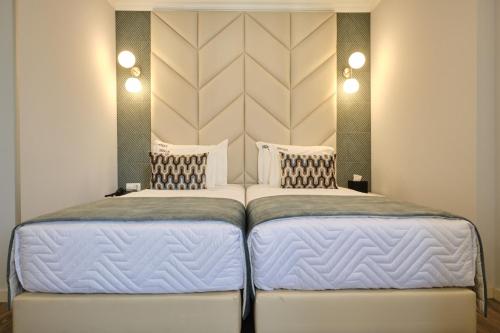 two beds sitting next to each other in a bedroom at Patria Hotel in Lisbon