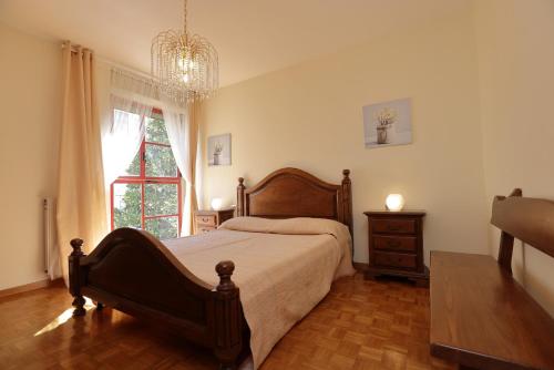 um quarto com uma cama, uma janela e um lustre em De chì e de là em Sestri Levante
