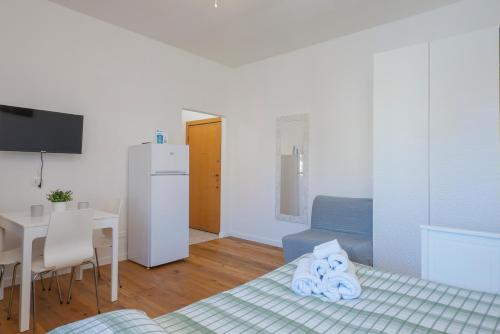Habitación con cama, mesa y nevera. en I Host Apartment - Fiuggi 59, en Milán