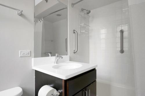 a white bathroom with a sink and a shower at Gold Coast 2BR w Gym Roof nr Mag Mile CHI-626 in Chicago