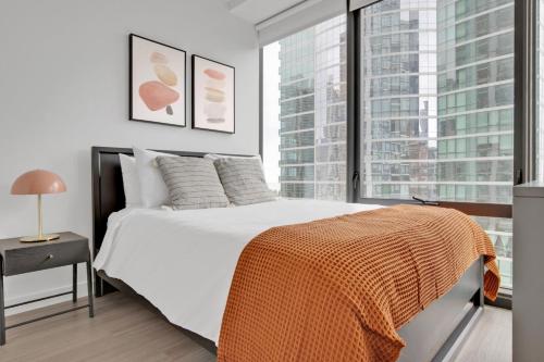 a bedroom with a white bed and a large window at S Loop 2BR w Pool Gym Spa nr Grant Park CHI-740 in Chicago