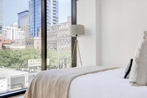 a bedroom with a large window with a view of a city at River N 1BR w Gym Pool WD nr Mag Mile CHI-440 in Chicago