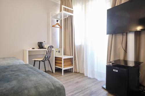 - une chambre avec un lit et un bureau avec une chaise dans l'établissement Patria Hotel, à Lisbonne