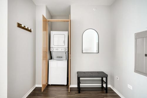 a small kitchen with a refrigerator and a stool at Streeterville 2br w pool gym nr Riverwalk CHI-881 in Chicago
