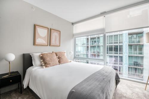 a bedroom with a white bed and two windows at Streeterville 2br w pool gym nr Riverwalk CHI-881 in Chicago