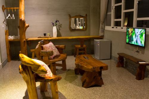 a living room with wooden furniture and a television at Water Reflections at Ease in Donggang