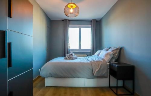 Un dormitorio con una cama con un osito de peluche. en Les Fins Nord, appartement 2 étoiles confortable a Annecy, en Annecy