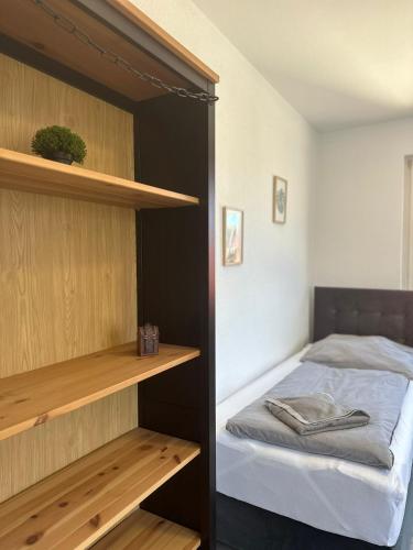 um quarto com uma cama e prateleiras de madeira em Green Park Apartment em Bremerhaven