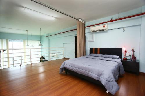 a bedroom with a bed and a wooden floor at Private Rock Climb at The CEO Penang in Bayan Lepas