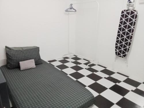 a room with a couch on a checkered floor at The Loft Bentong in Bentong