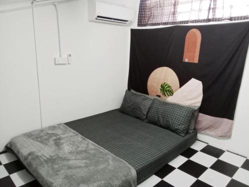 a small bed in a room with a checkered floor at The Loft Bentong in Bentong