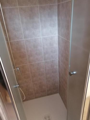 une douche avec une porte vitrée dans une salle de bain dans l'établissement Lanteuil Maison de vacances à côté de brive et collonge la rouge, à Lanteuil