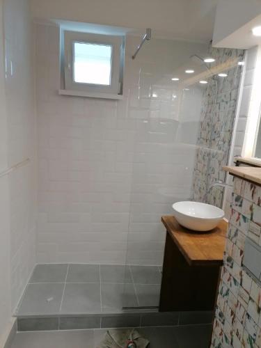 La salle de bains blanche est pourvue d'un lavabo et d'une douche. dans l'établissement Locatia perfecta in centru, à Cluj-Napoca