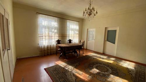 une salle à manger avec une table et un lustre dans l'établissement Дом с оленями, à Gyumri