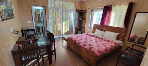 a bedroom with a bed and a desk and a window at Casa Arhan 2-3-4-7-12 BHK Luxury Penthouse in Mussoorie