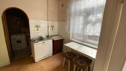 a small kitchen with a sink and a window at Дом с оленями in Gyumri