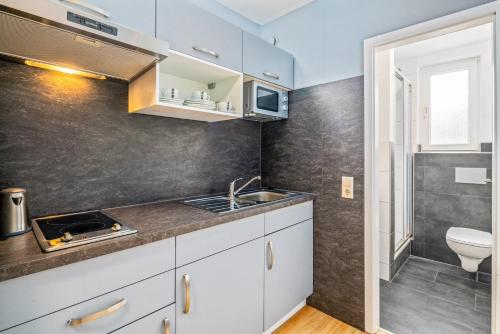 a small kitchen with a sink and a toilet at Hotel Am Gottesauer Schloss in Karlsruhe