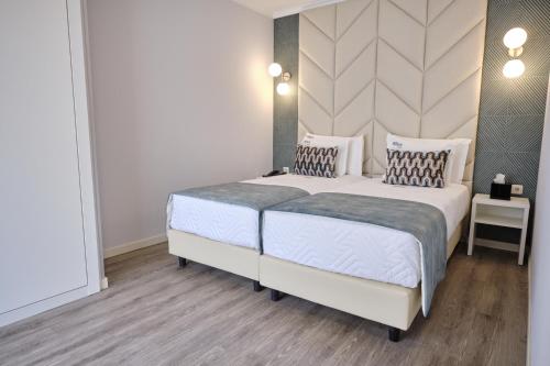 a bedroom with a large white bed with two pillows at Patria Hotel in Lisbon