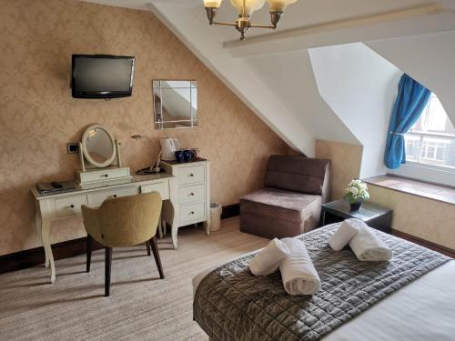 a bedroom with a bed and a desk with a mirror at Llety Teifi Guest House in Cardigan