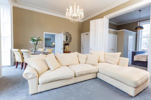 a living room with a white couch and a dining room at Elizabeth House Flat 2 in Cheltenham