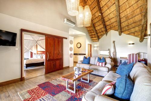 uma sala de estar com um sofá e uma mesa em Ilala Lodge Hotel em Victoria Falls