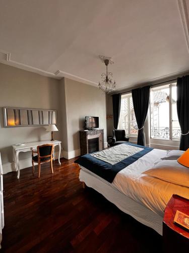 a bedroom with a large bed and a desk with a computer at Le Jardin des Lys in Saint-Léonard-de-Noblat
