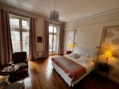 a bedroom with a bed and a chair and a window at Le Jardin des Lys in Saint-Léonard-de-Noblat