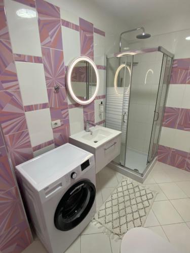 La salle de bains est pourvue d'un lave-linge et d'un lavabo. dans l'établissement Merville Apartment 6, à Durrës