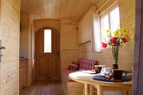 - une petite cuisine avec une table dans une cabane en bois dans l'établissement La roulotte du Leff, à Le Faouët
