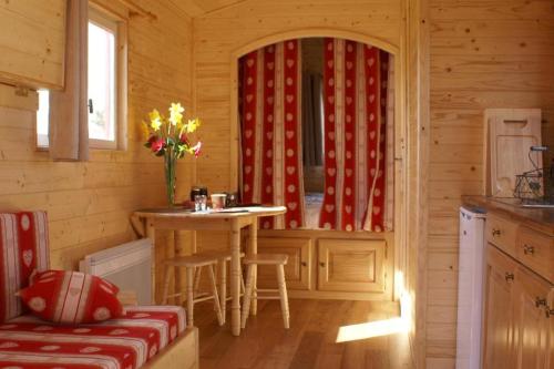 une cuisine avec une table et des chaises dans une cabine dans l'établissement La roulotte du Leff, à Le Faouët