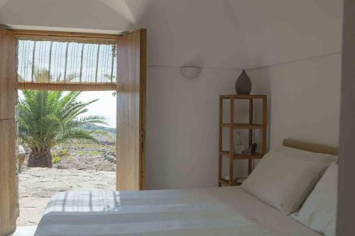 a bedroom with a bed with a view of the beach at Tenuta Borgia in Pantelleria