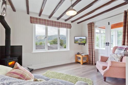 a living room with a couch and a fireplace at Badger's Cottage with stunning lake & mountain views in Coniston