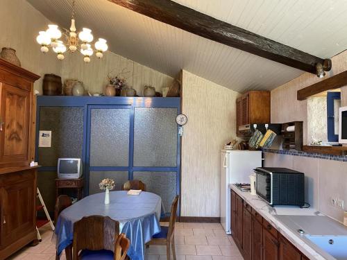 a kitchen with a table and a white refrigerator at Le balét in Asnois