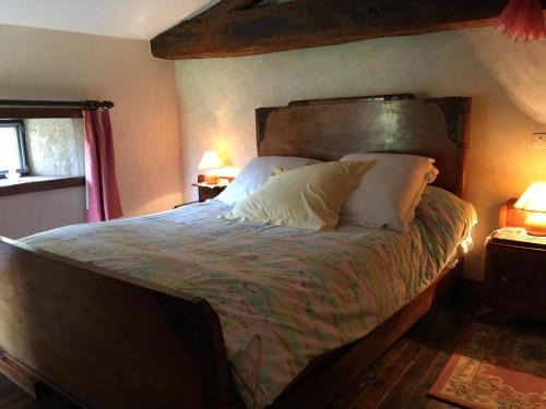 a bedroom with a large bed with a wooden headboard at Le balét in Asnois