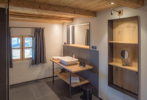 W łazience znajduje się umywalka i lustro. w obiekcie Geigelstein Chalets w mieście Unterwössen