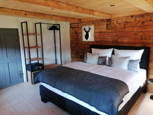 a bedroom with a large bed and a wooden wall at Geigelstein Chalets in Unterwössen