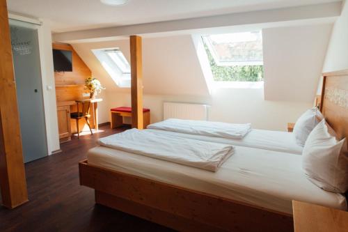 a bedroom with two beds and a window at Bräuhaus Ummendorf in Ummendorf-Biberach