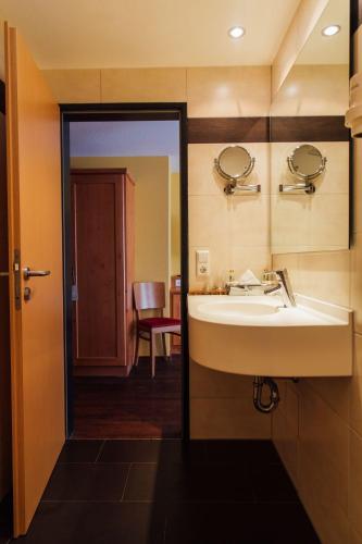 a bathroom with a sink and a mirror at Bräuhaus Ummendorf in Ummendorf-Biberach