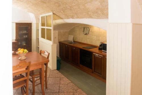 a kitchen with a wooden table and a dining room at La Casa dell'oste in Monopoli