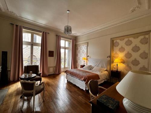 a bedroom with a bed and a table and chairs at Le Jardin des Lys in Saint-Léonard-de-Noblat