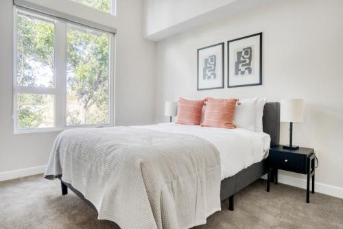 a white bedroom with a large bed with orange pillows at Menlo Park 1BR w Lounge WD nr Caltrain SFO-993 in Menlo Park