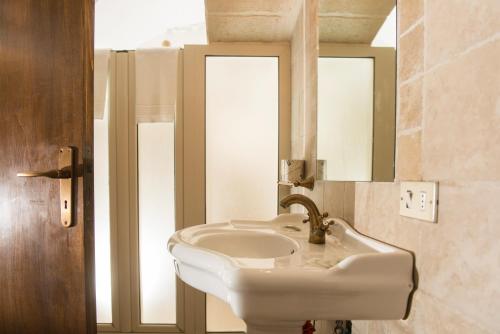 a bathroom with a white sink and a mirror at La Casa dell'oste in Monopoli