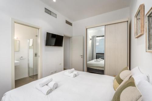 a bedroom with a white bed with two towels at Luxury 3BR on Frishman SEA u TLV in Tel Aviv
