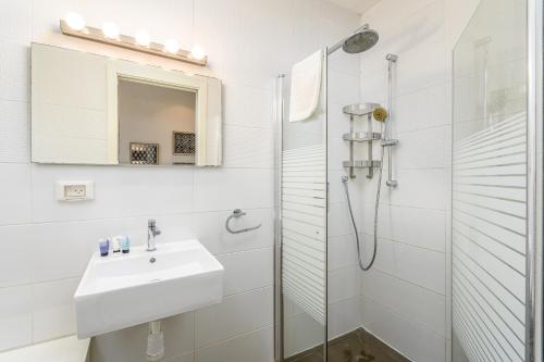 a white bathroom with a sink and a shower at Luxury 3BR on Frishman SEA u TLV in Tel Aviv