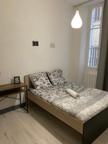 - une chambre avec un lit, une table et une fenêtre dans l'établissement La Plénitude Marseillaise - T4 de 70 m2, 3 chambres, centre-ville, 8 couchages, à Marseille