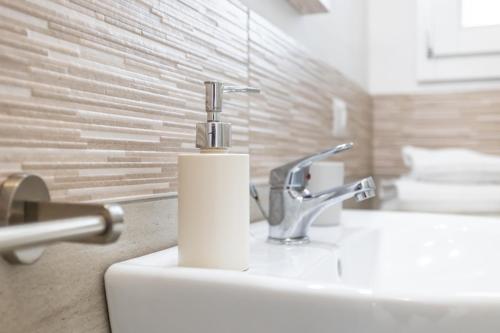 a bathroom sink with a soap dispenser on it at Appartamenti Rocca 'Ja in Castelsardo