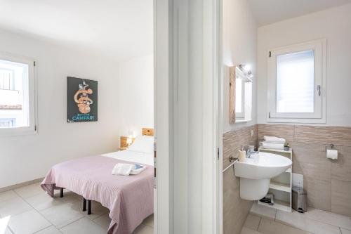 a bathroom with a bed and a sink in a room at Appartamenti Rocca 'Ja in Castelsardo