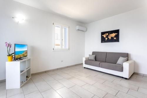 a living room with a couch and a tv at Appartamenti Rocca 'Ja in Castelsardo