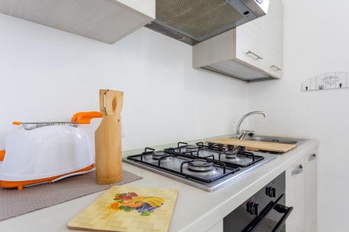 a kitchen counter with a stove and a sink at Appartamenti Rocca 'Ja in Castelsardo