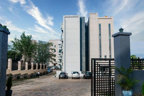 um edifício com carros estacionados em frente em Elizabeth Golf Apartment by Link em Kigali